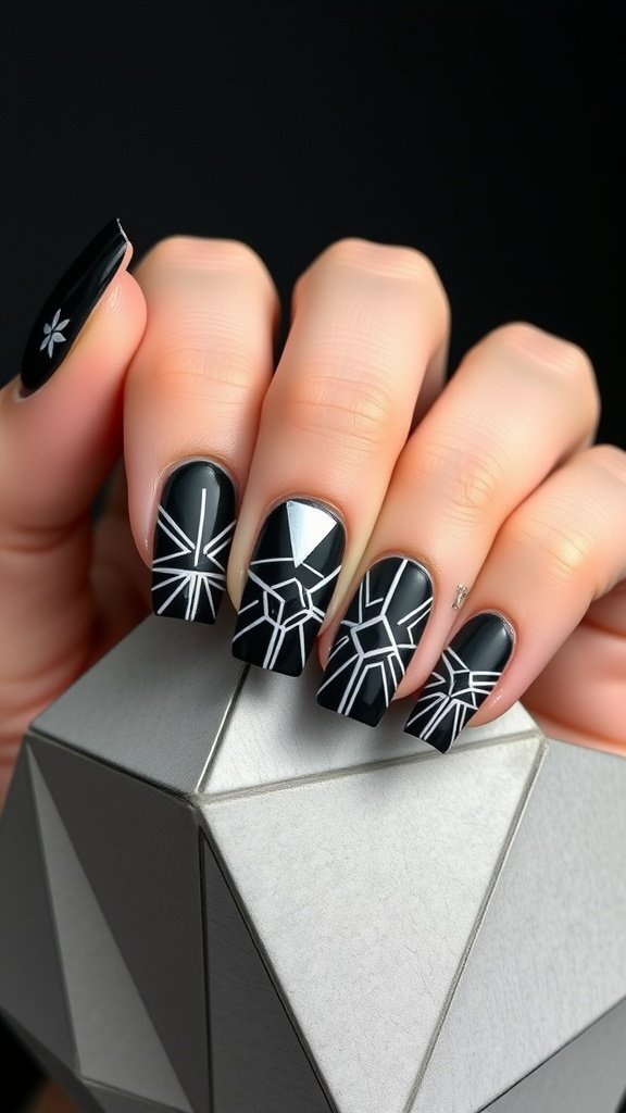 A hand with black geometric nail designs featuring white patterns.
