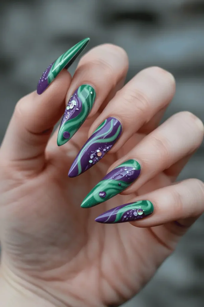 Green and purple swirl nail art with glitter accents, giving magical potion vibe. Long stiletto nails, fantasy-inspired styling.