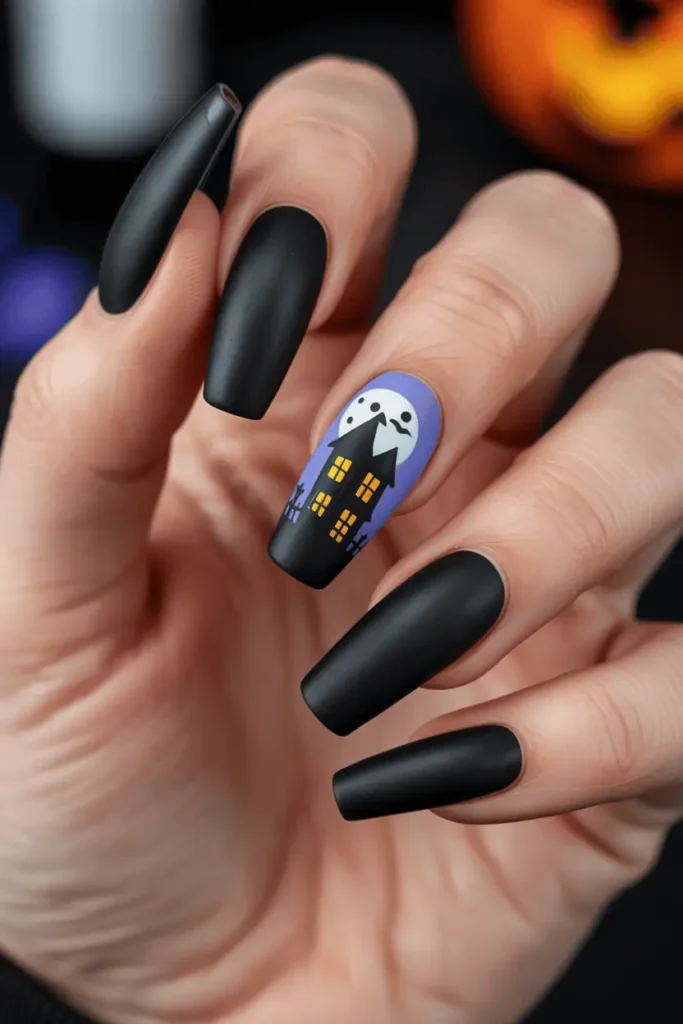 One accent nail with a cartoon-style haunted house and moon, rest painted matte black. Shot close-up on long coffin nails, Halloween night party background.