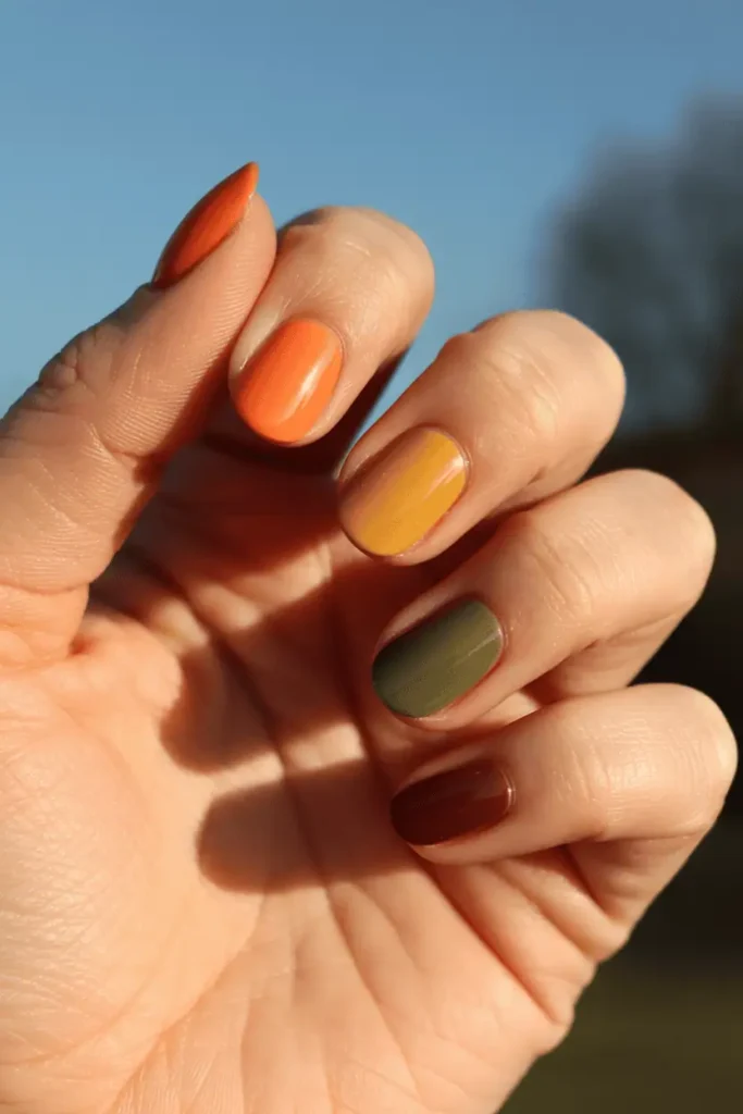 Multi-colored autumn palette nails (orange, mustard, olive, burgundy).