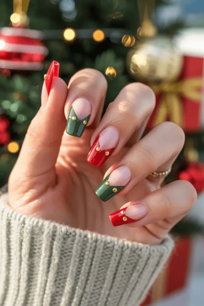 French-tip nails shaped like elf hats, alternating red and green, gold dots at tips.